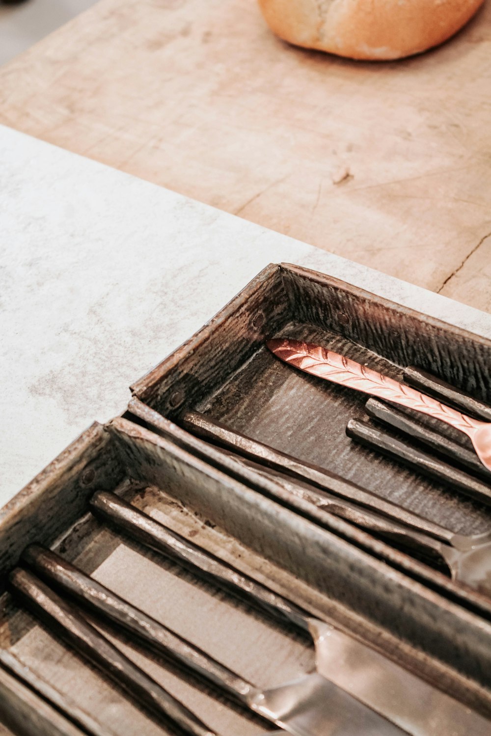 a knife, fork, spoon and spoon rest on a tray