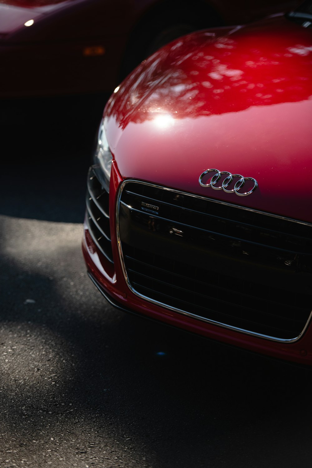 a close up of a red car parked in a parking lot