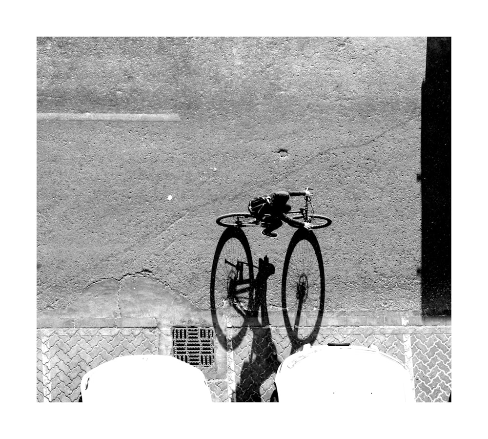 grayscale photography of person riding on bike