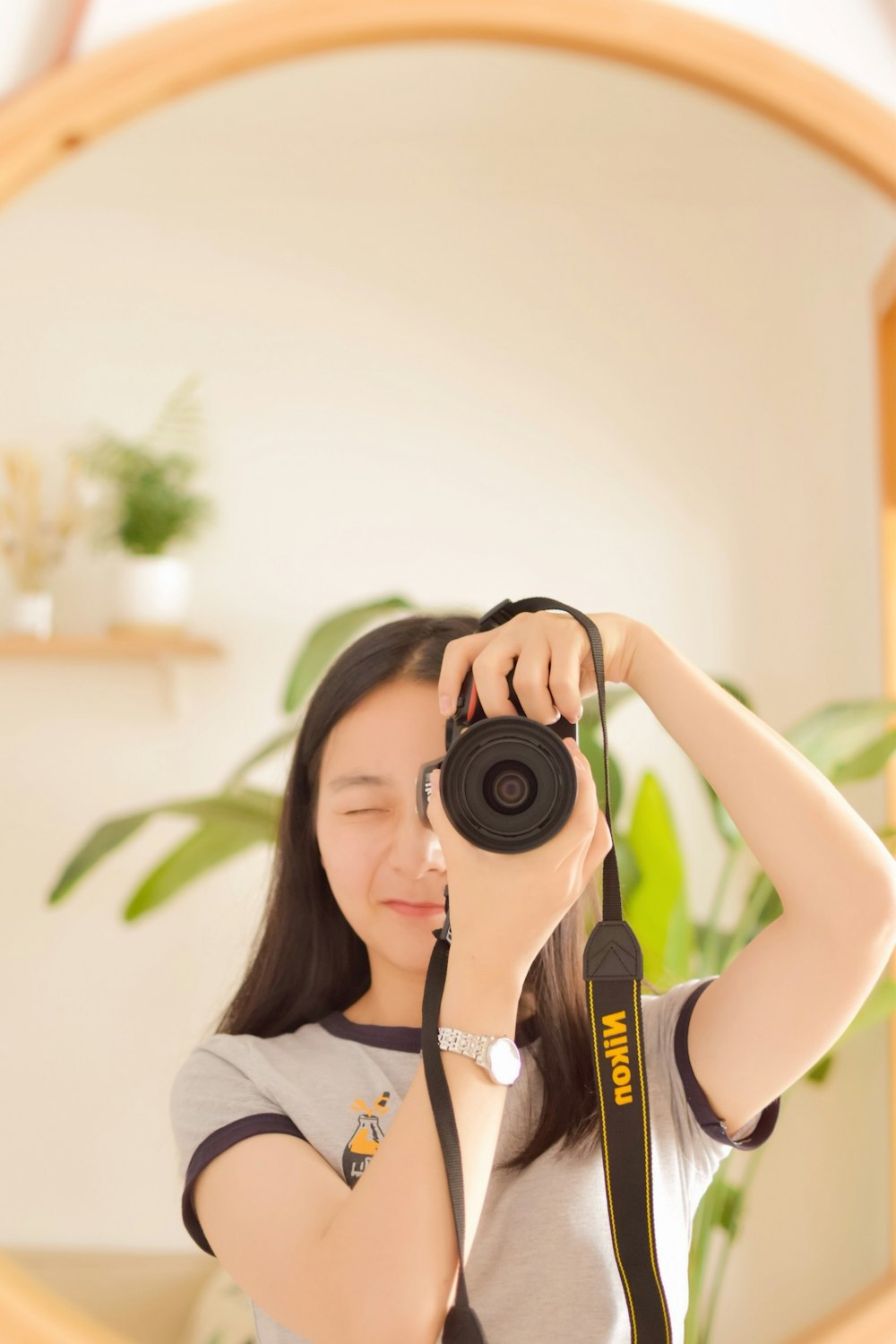 woman standing and using black Nikon DSLR camera