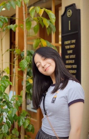 a woman standing in front of a green plant