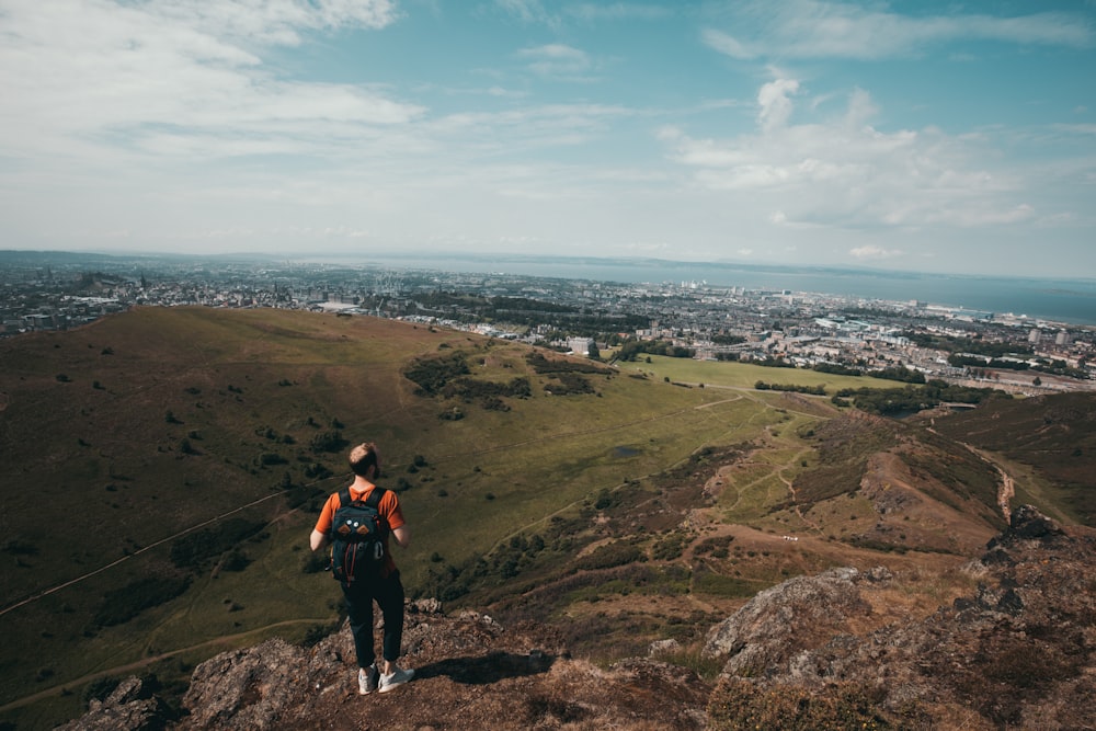 person wearing orange shirt standing across horizon