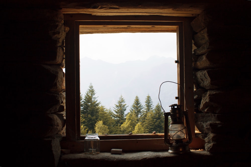 black lantern lamp near open window viewing green trees