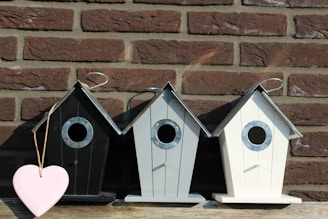 Children building a small wooden birdhouse together.