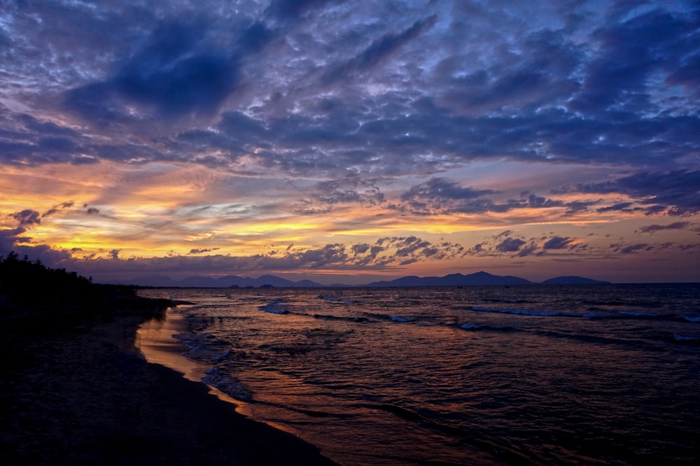 calm sea under blue and yellow skies