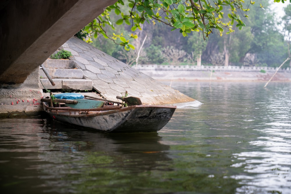 empty boat docked beside bridge