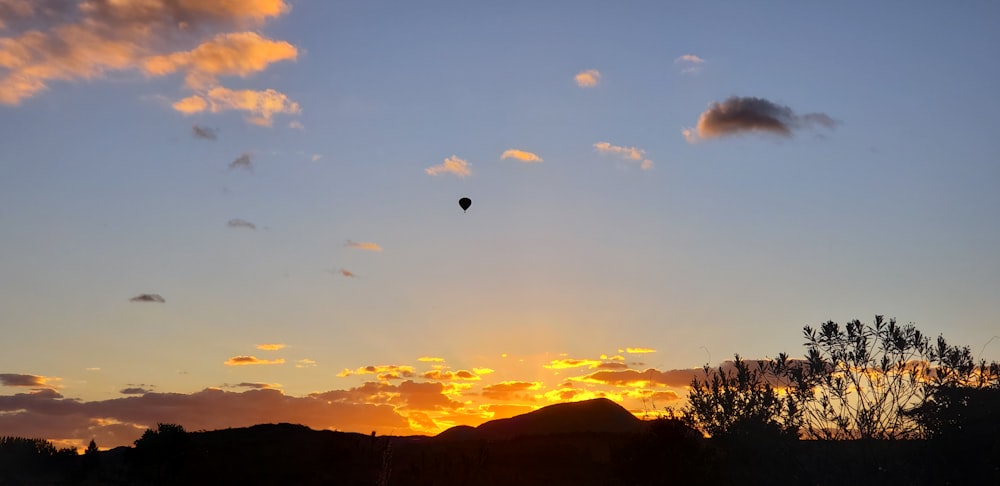 Ein Heißluftballon, der bei Sonnenuntergang am Himmel fliegt