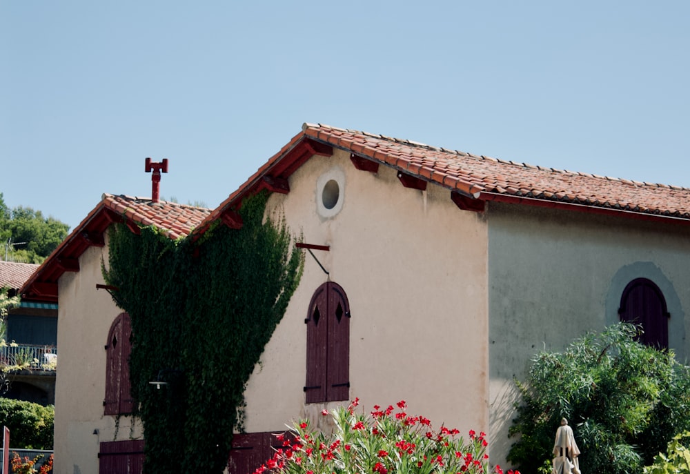 un bâtiment avec un toit rouge et une croix sur le dessus