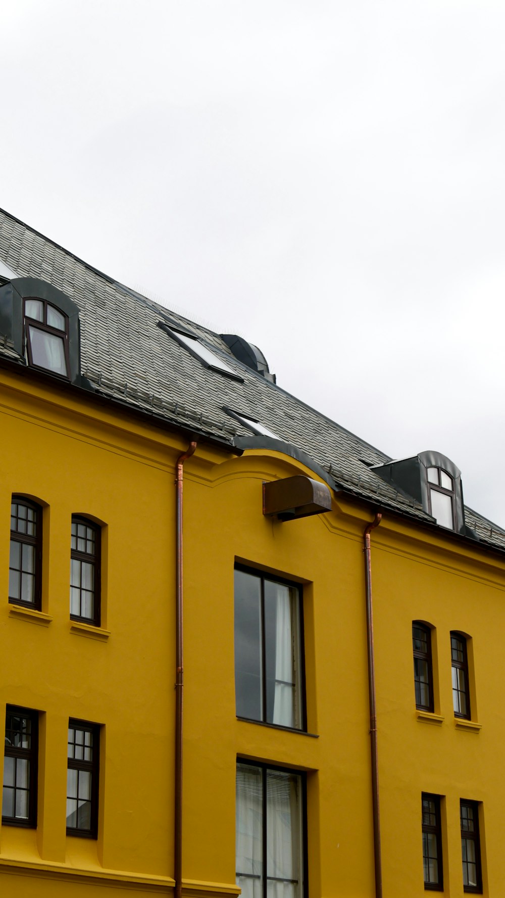 a large yellow building with a black roof