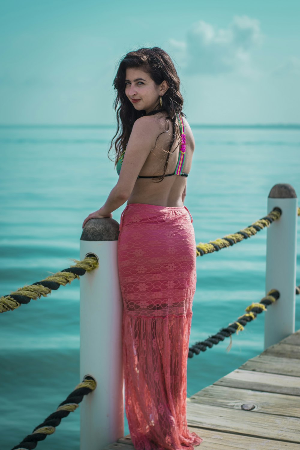woman wearing pink lace maxi skirt standing on dock