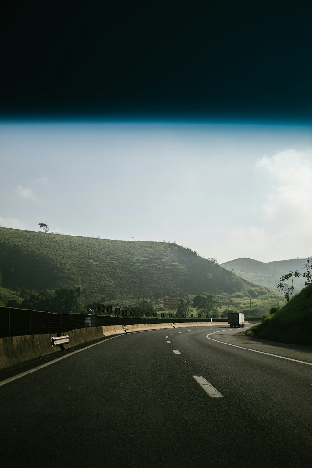 black asphalt road between green mountains