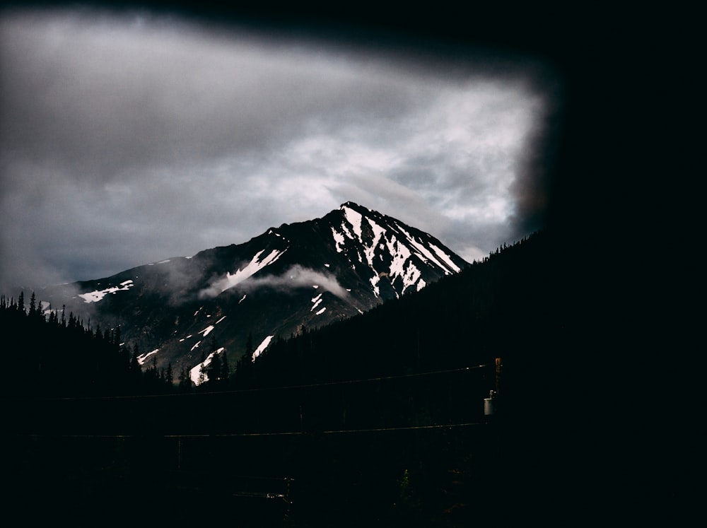 snowy mountain under cloudy sky