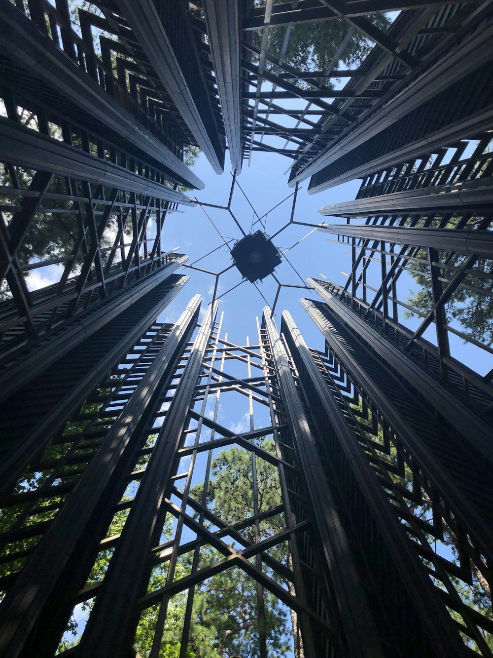 gray steel high-rise post surrounded with tall and green trees