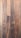 Dark wooden planks with visible grain patterns and some knots create a rustic and textured surface. The wood has various shades of brown, ranging from light to dark tones, adding depth and character.