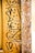 A detailed wooden panel features ornate floral carvings on the right with intricate patterns, while elegant calligraphic script in black ink adorns the left side of the panel, contrasting beautifully with the wood's natural tones.