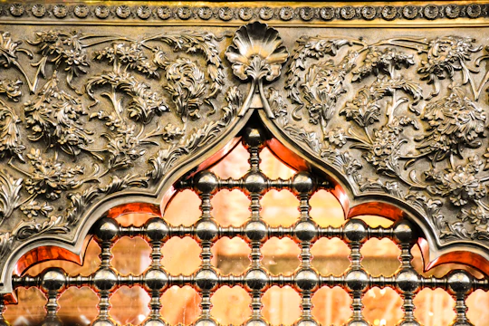 Close-up of a glowing plasma-cut metal wall piece with detailed floral patterns.