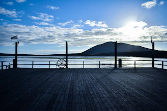 Elegant wooden deck with blue water tones and vintage maritime details at sunset.