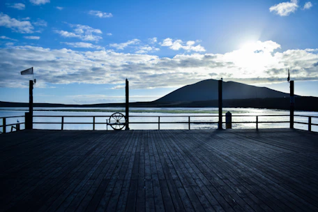 Elegant wooden deck with blue water tones and vintage maritime details at sunset.