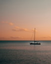 black yacht anchored at sea during sunset