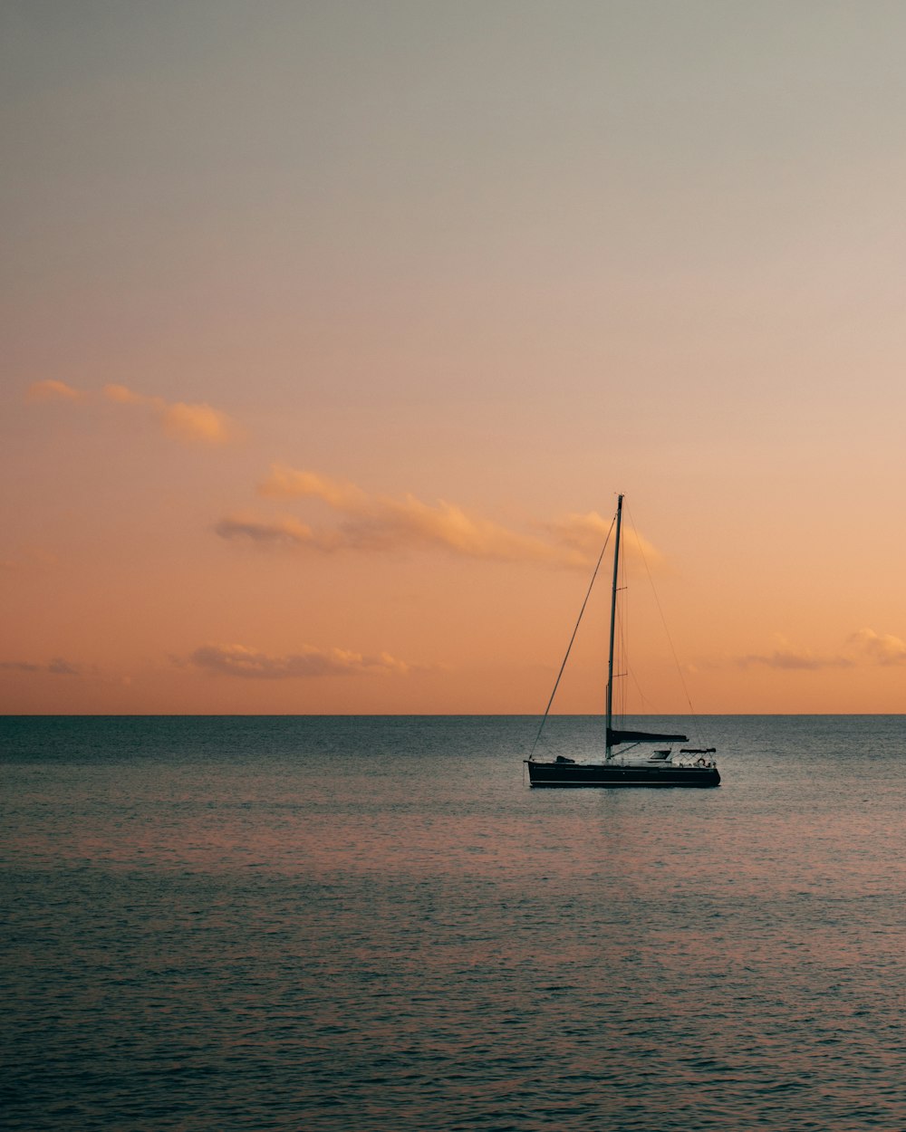 Schwarze Yacht ankert bei Sonnenuntergang auf See