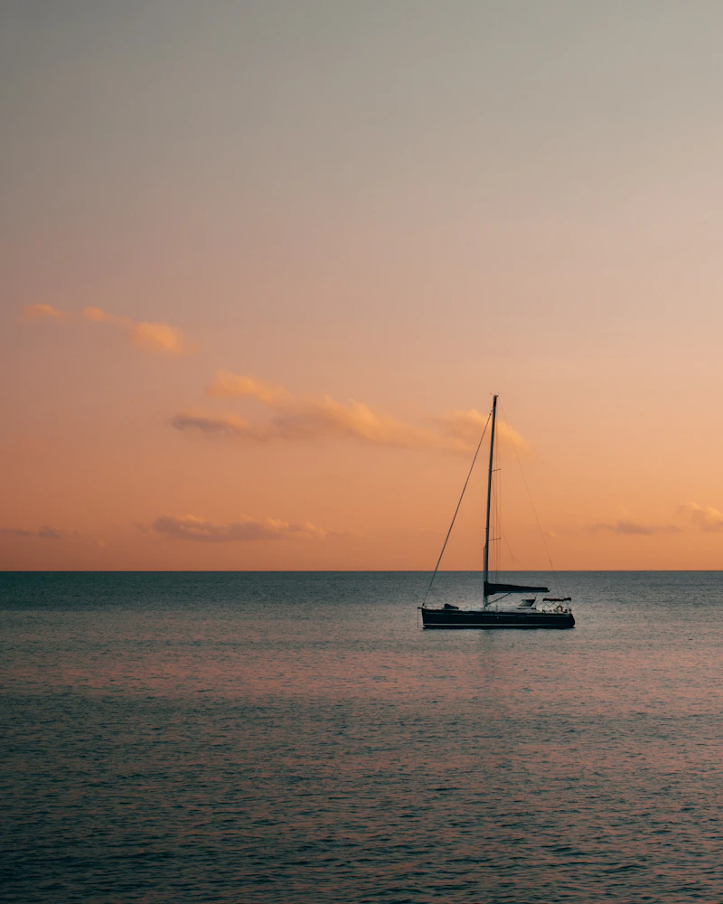 Sailing yacht resting on calm water under a dusk sky