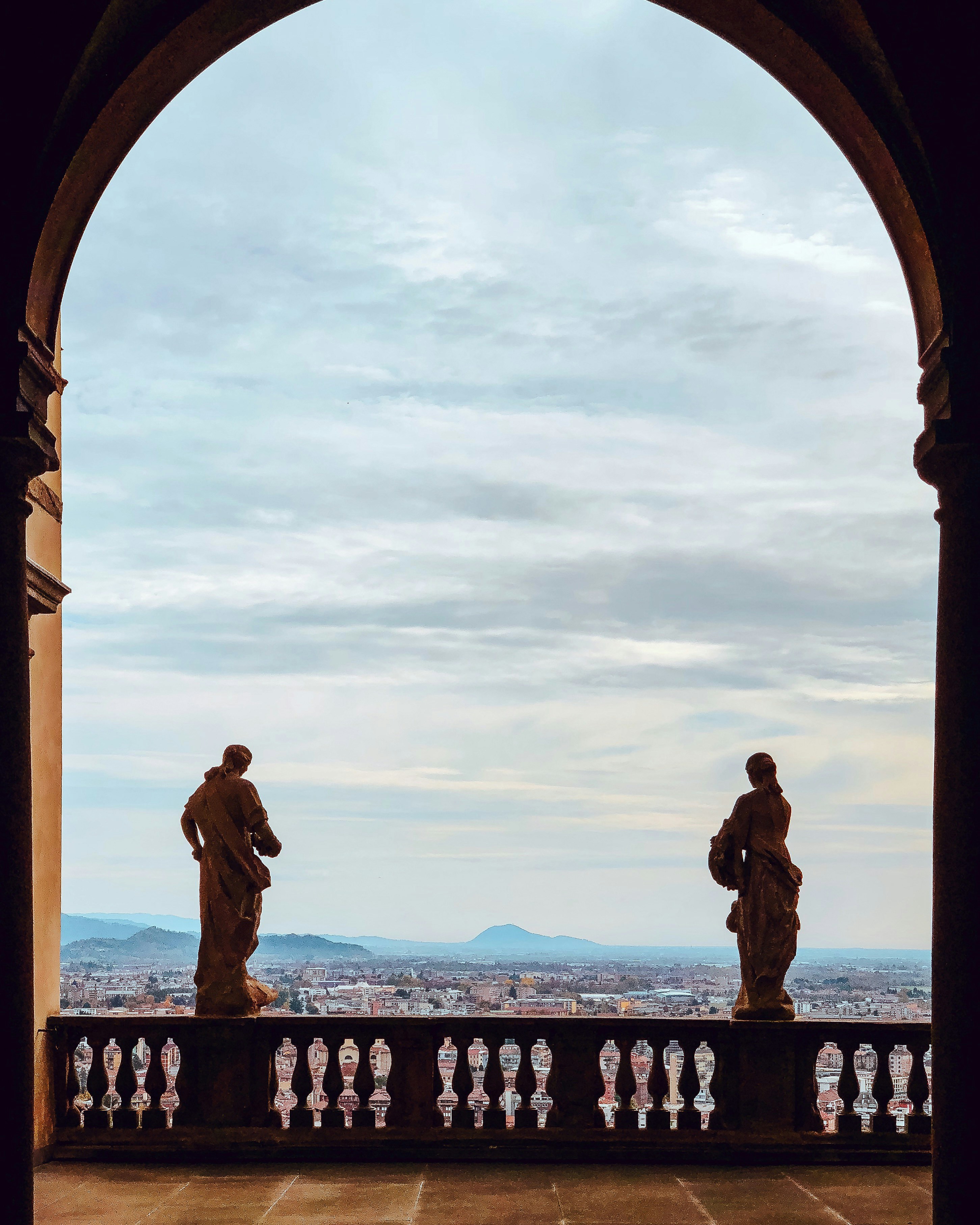 two statues on balcony railing during day