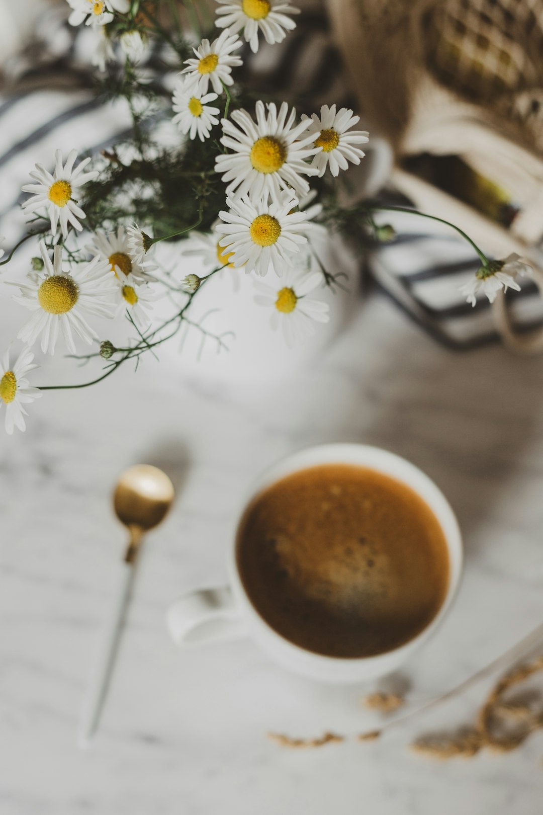 selective focus photography of white flower arrangement beside mug of coffee