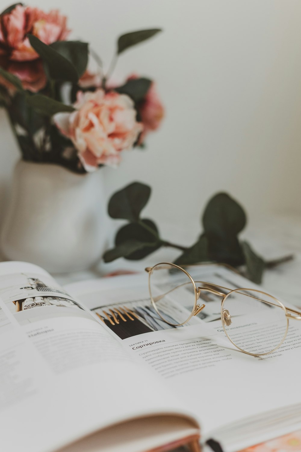 gold-colored framed eyeglasses on book