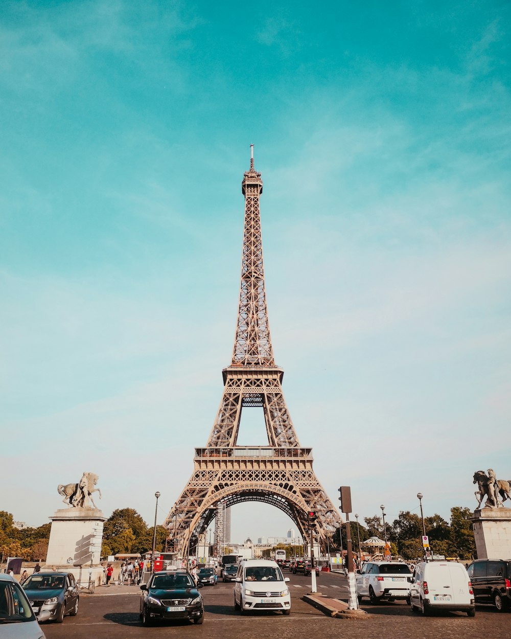 cars travelling on road heading towards Eiffel Tower