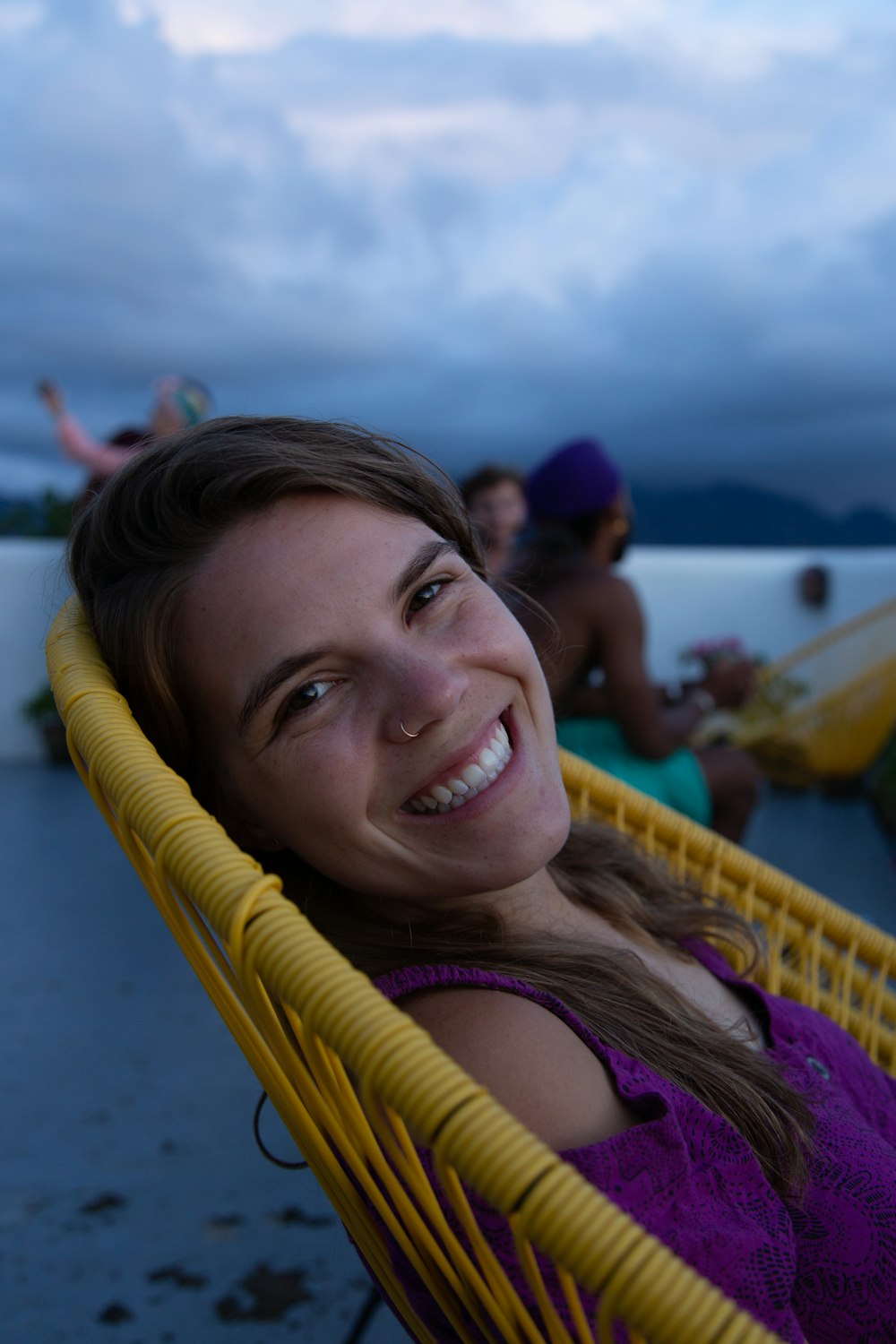 smiling woman wearing purple cold-shoulder top sitting on chair