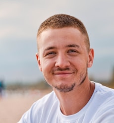 man wearing white crew-neck shirt outdoor selective focus photography