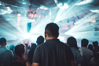 A dazzling crowd at a night entertainment event under red and gold lights.