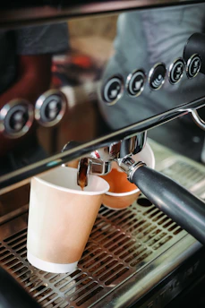 A sturdy coffee vending machine dispensing a fresh cup of coffee with steam rising.