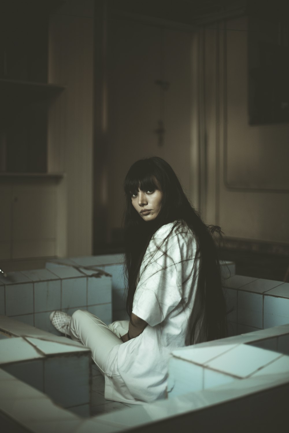 woman sitting on white tiles