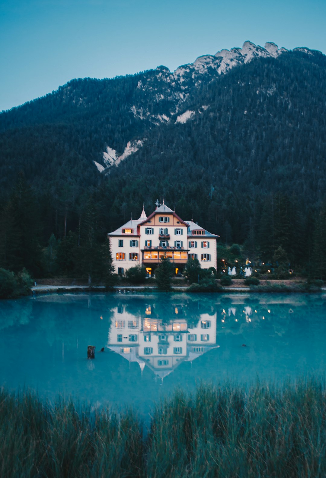white and gray hotel by a lake