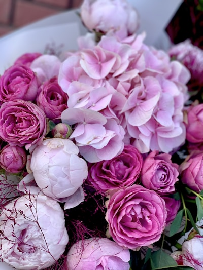 A soft, romantic bouquet of blush pink roses and white peonies tied with a silk ribbon.