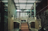 A grand staircase with a broken grid railing design, blending industrial and elegant elements.