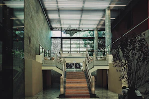 A grand staircase with a broken grid railing design, blending industrial and elegant elements.