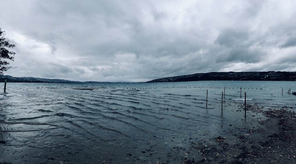 body of water near mountains at daytime