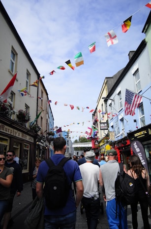 A busy street scene in Tripoli showing local shops with Libyan flags gently waving.