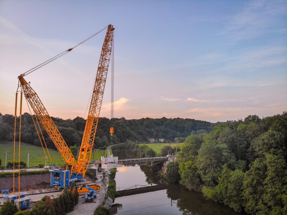 A modern crane truck lifting heavy cargo at a busy construction site in Vietnam.