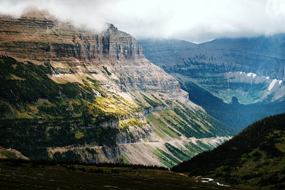 a scenic view of a valley with mountains in the background