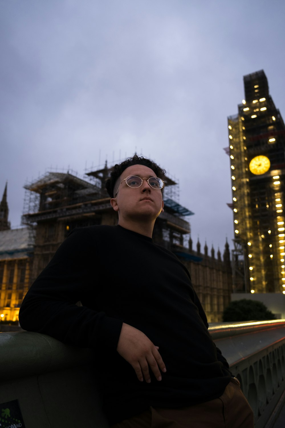 man in black crew-neck sweater standing near building