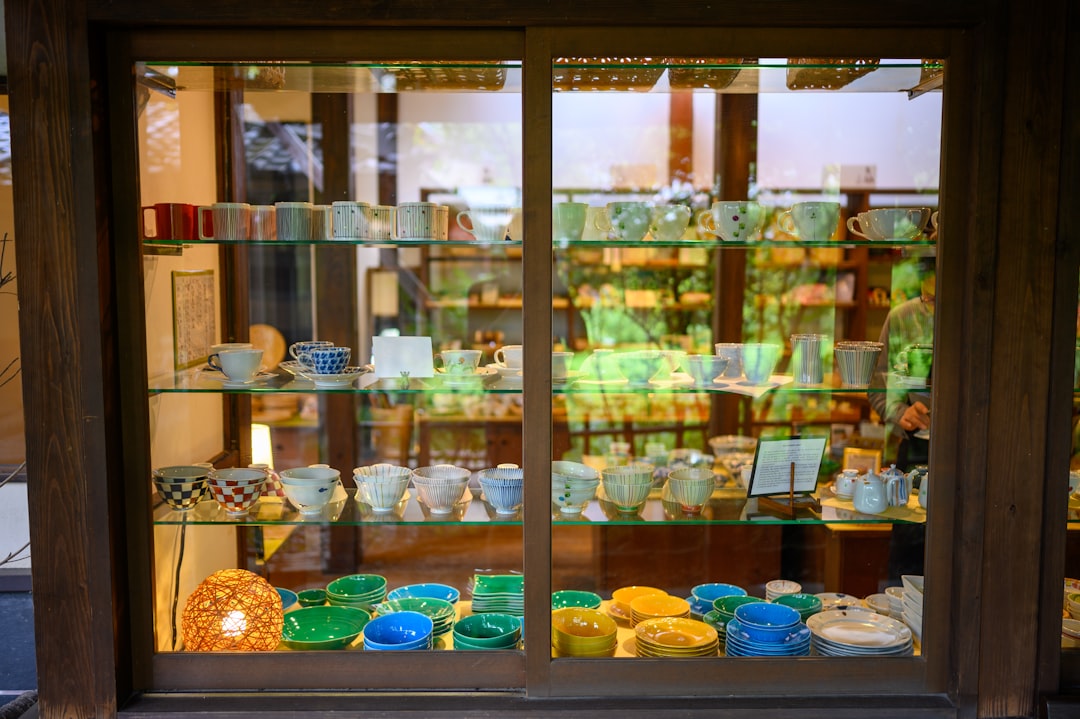 assorted-color ceramic cups display by the window