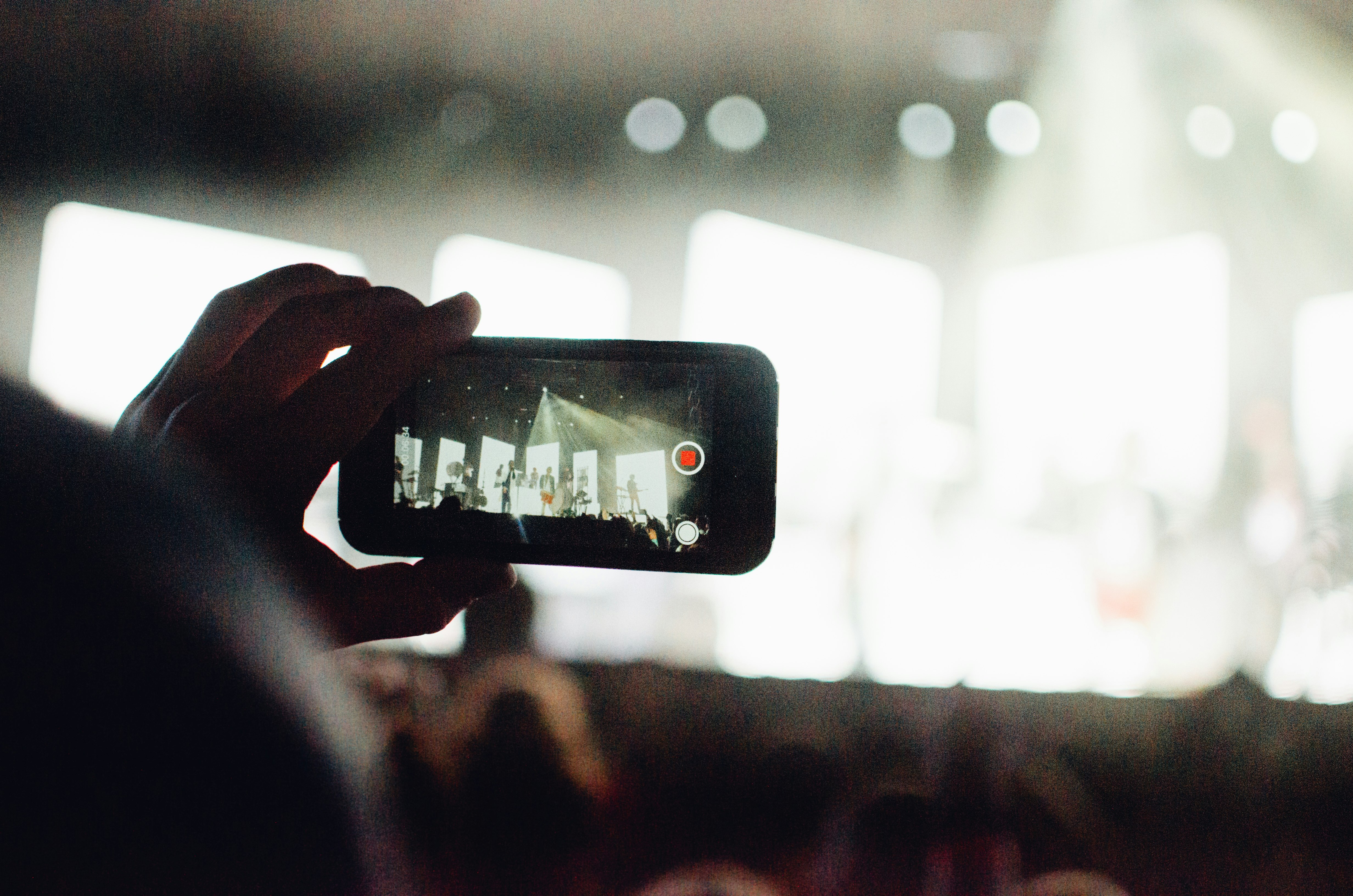 This photo was taken at the ALIVE Christian Musical Festival in 2019. There were so many great concerts and so many good photos to be taken, but the real treat was seeing what the crowd took notice of and wanted to remember. This is a photo of a man taking a video of one of the concerts using his Apple iPhone, so that he could remember this moment for the rest of his life.