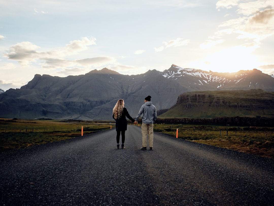 A couple standing on a road less traveled.