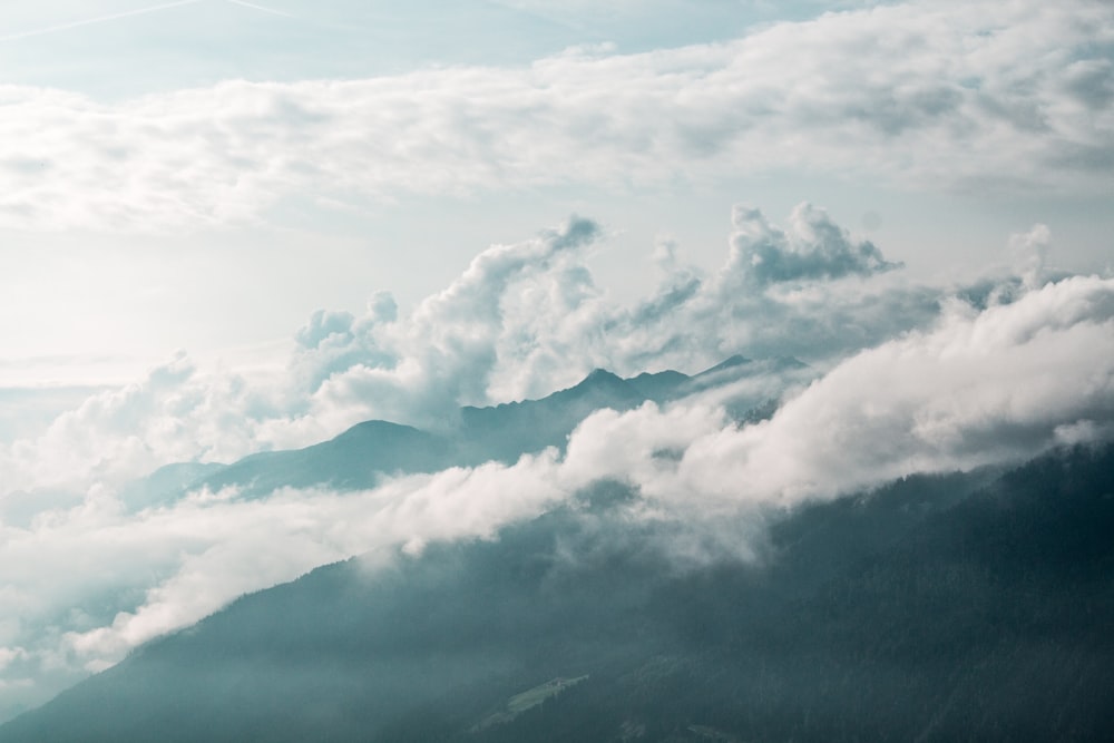 a plane flying over a mountain covered in clouds