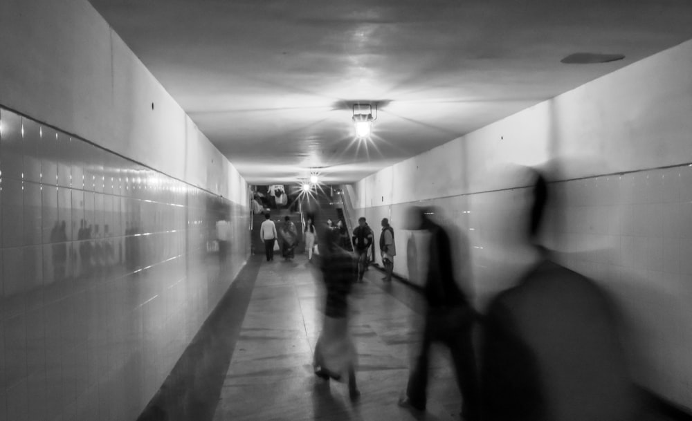 grayscale photo of people in corridor