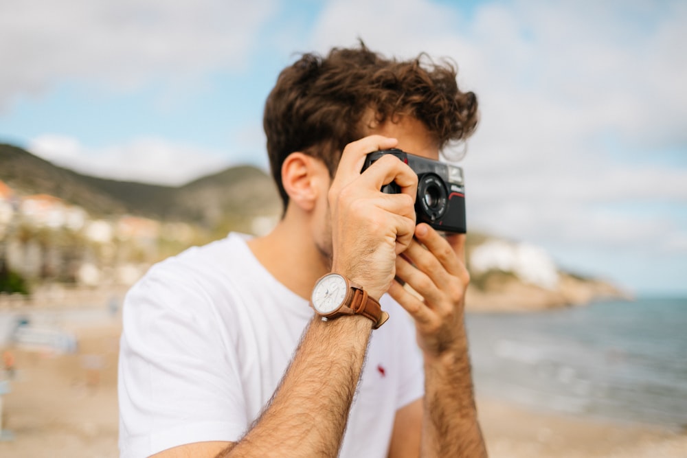 Fotografía de enfoque superficial Persona desconocida usando cámara negra al aire libre