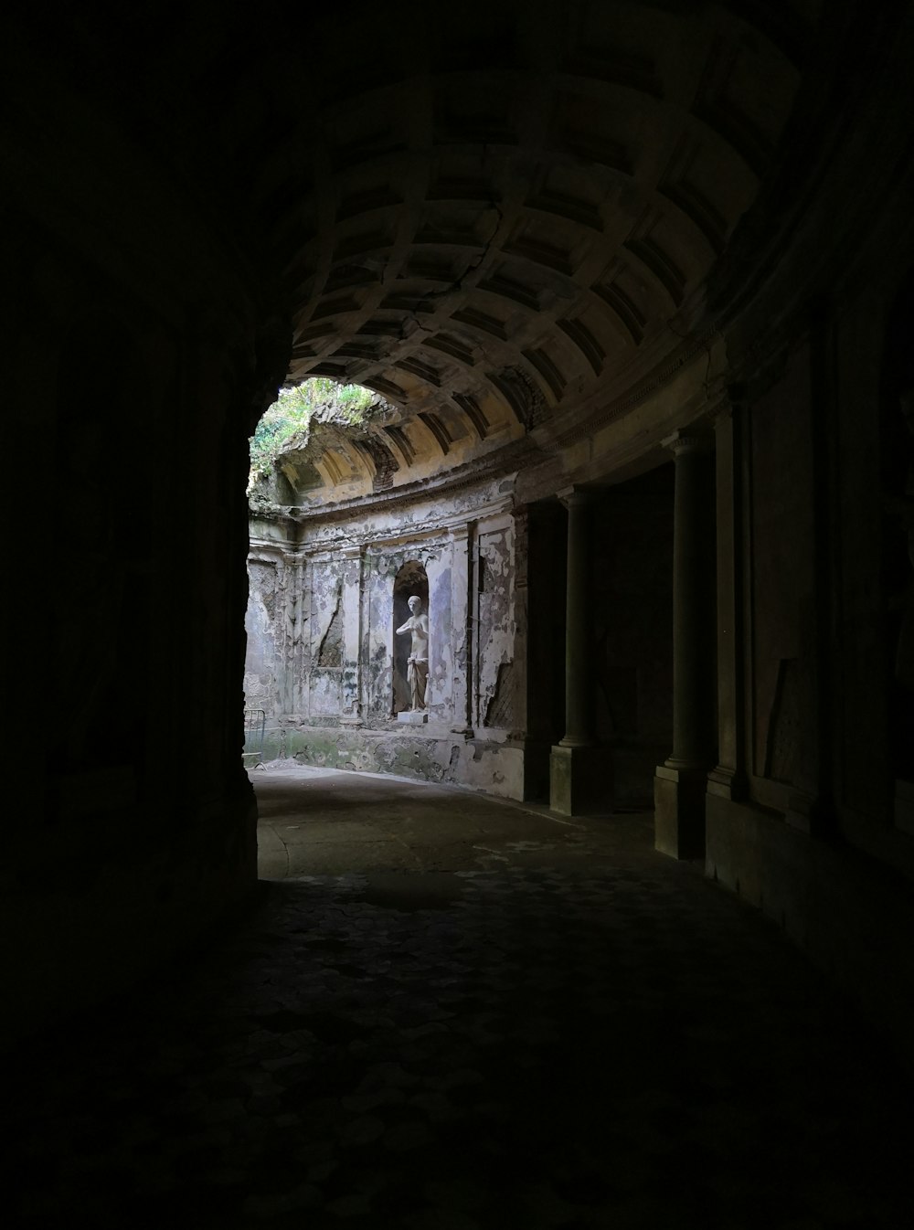 un tunnel sombre avec une statue au milieu